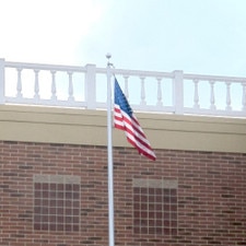 flag on pole against brick wall